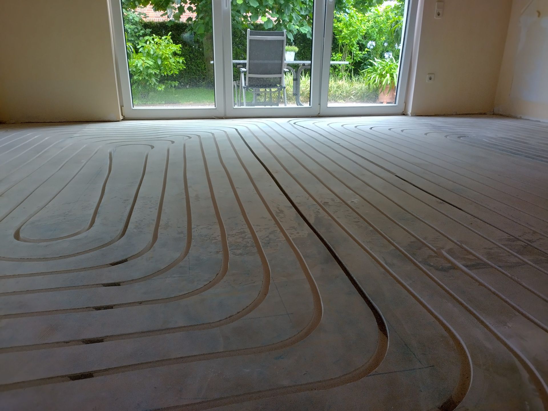 Ein Raum mit einer Glasschiebetür und einem Stuhl im Hintergrund