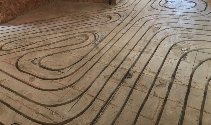 Eine Nahaufnahme eines Holzbodens mit Rohren, die hindurch verlaufen.