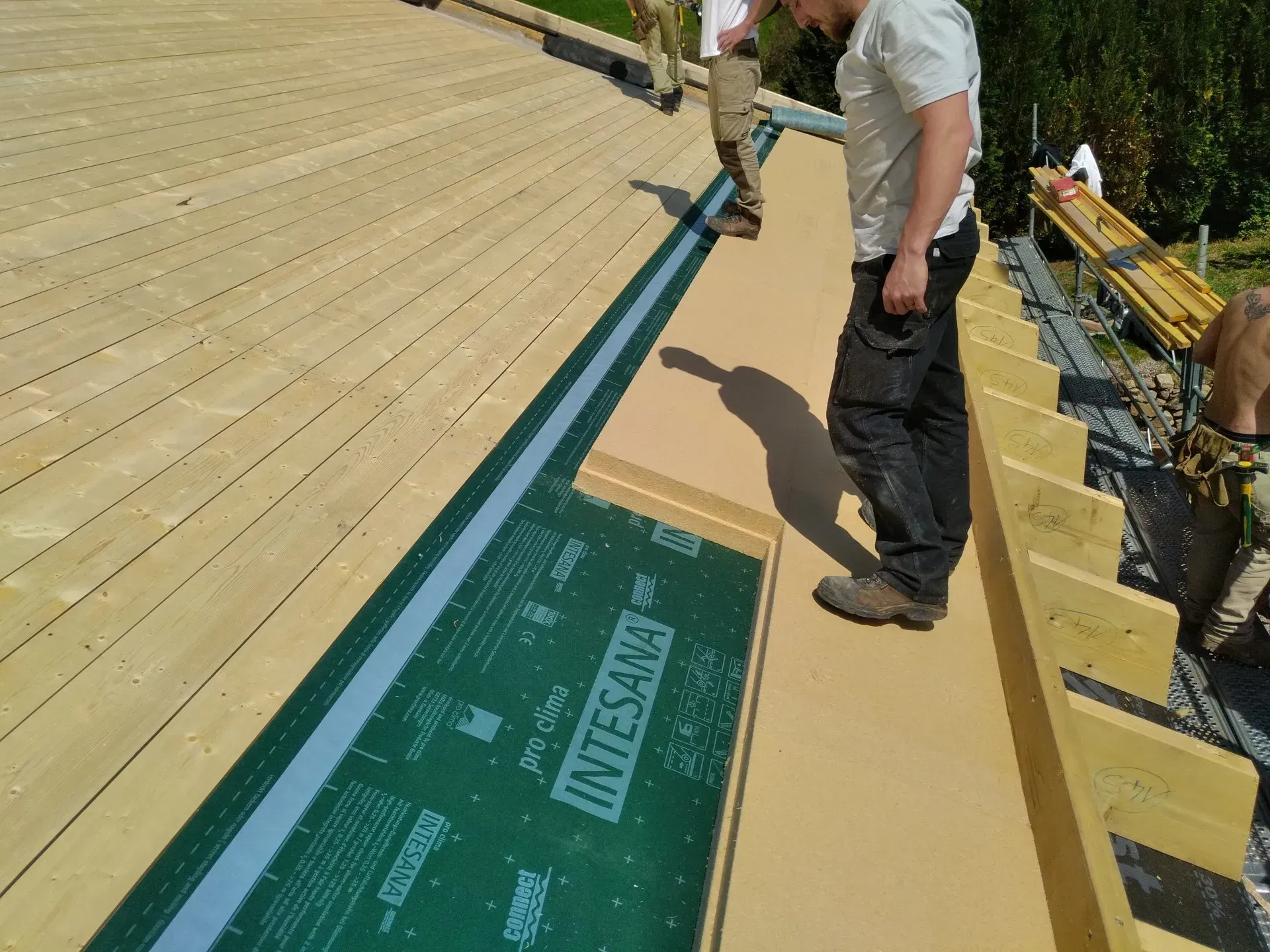 Un homme posant l'isolation du toit avec de la laine de verre