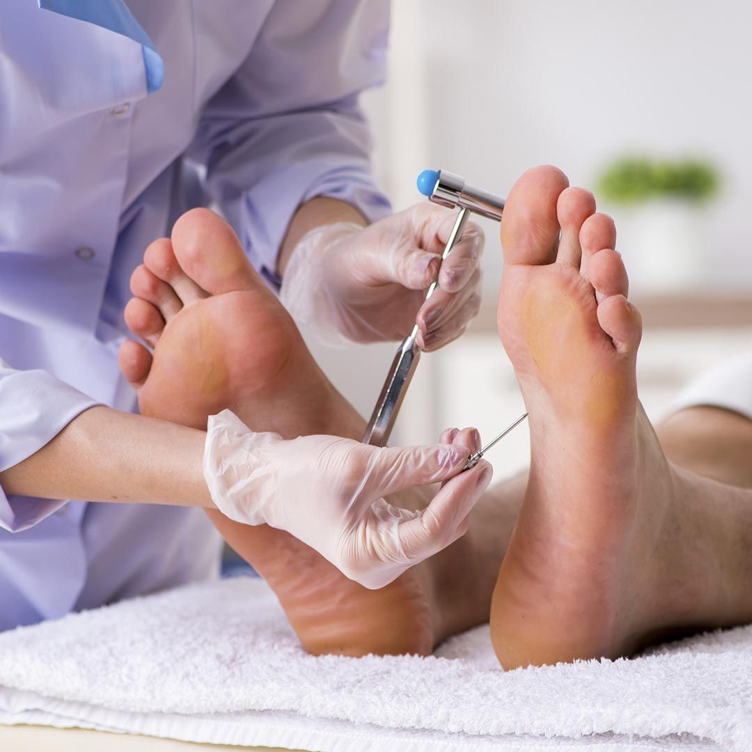 Una persona se está haciendo examinar los pies por un médico.