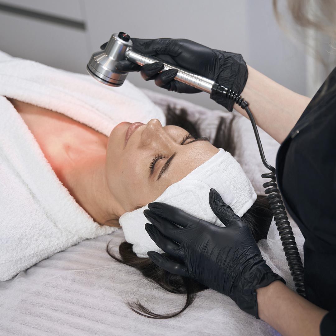 Una mujer está acostada en una cama recibiendo un tratamiento facial.