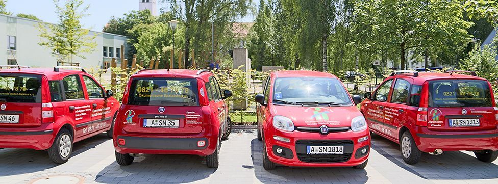 Vier identische rote Fiat Panda Fahrzeuge parken an einem sonnigen Tag im Freien in einer Reihe.