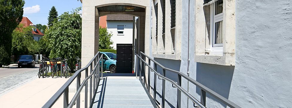 Eine Gruppe von Menschen steht und kniet auf einer Rasenfläche im Freien und lächelt für ein Gruppenfoto.