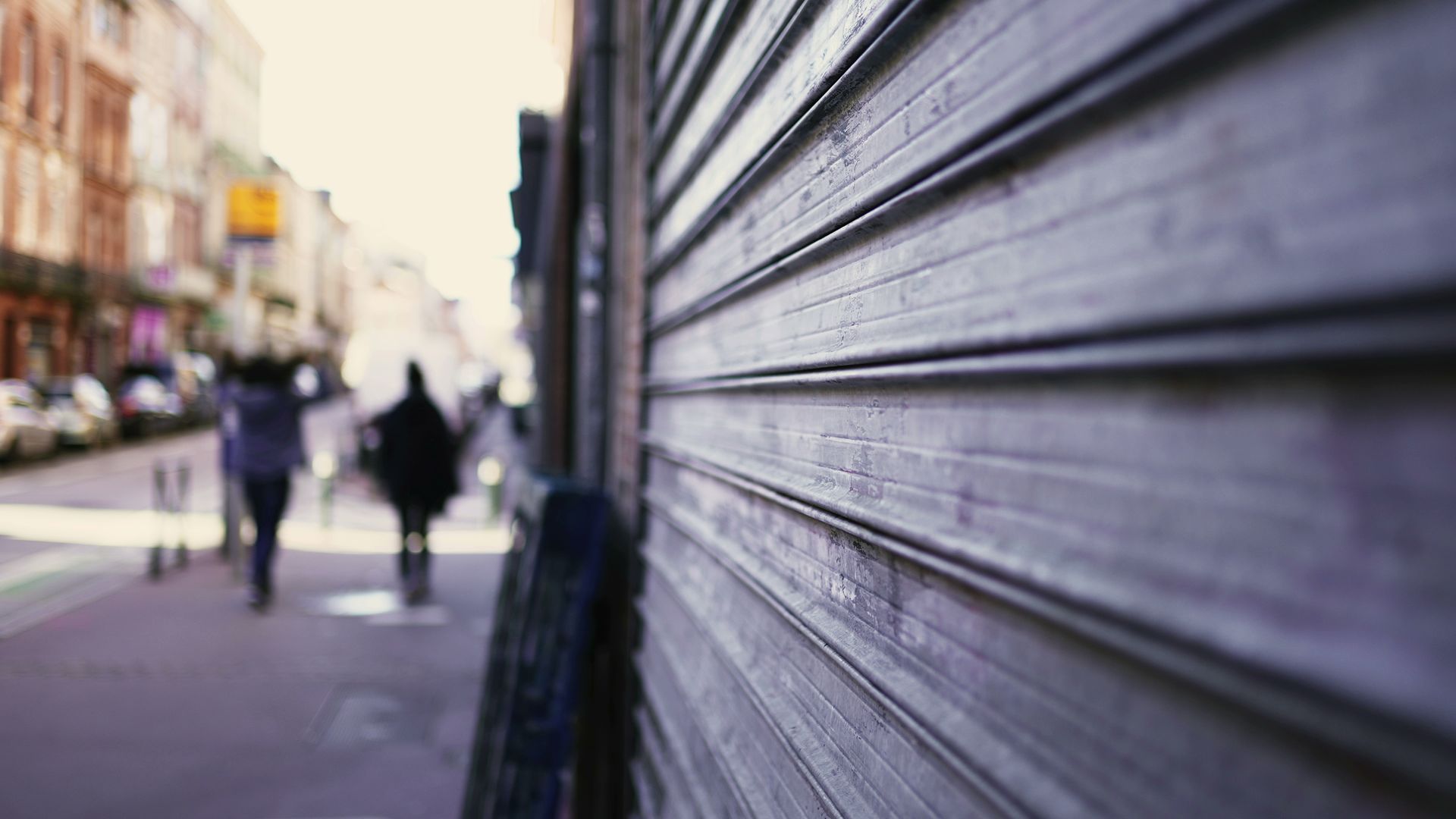 Très gros plan sur des rideaux métalliques fermés dans une rue.