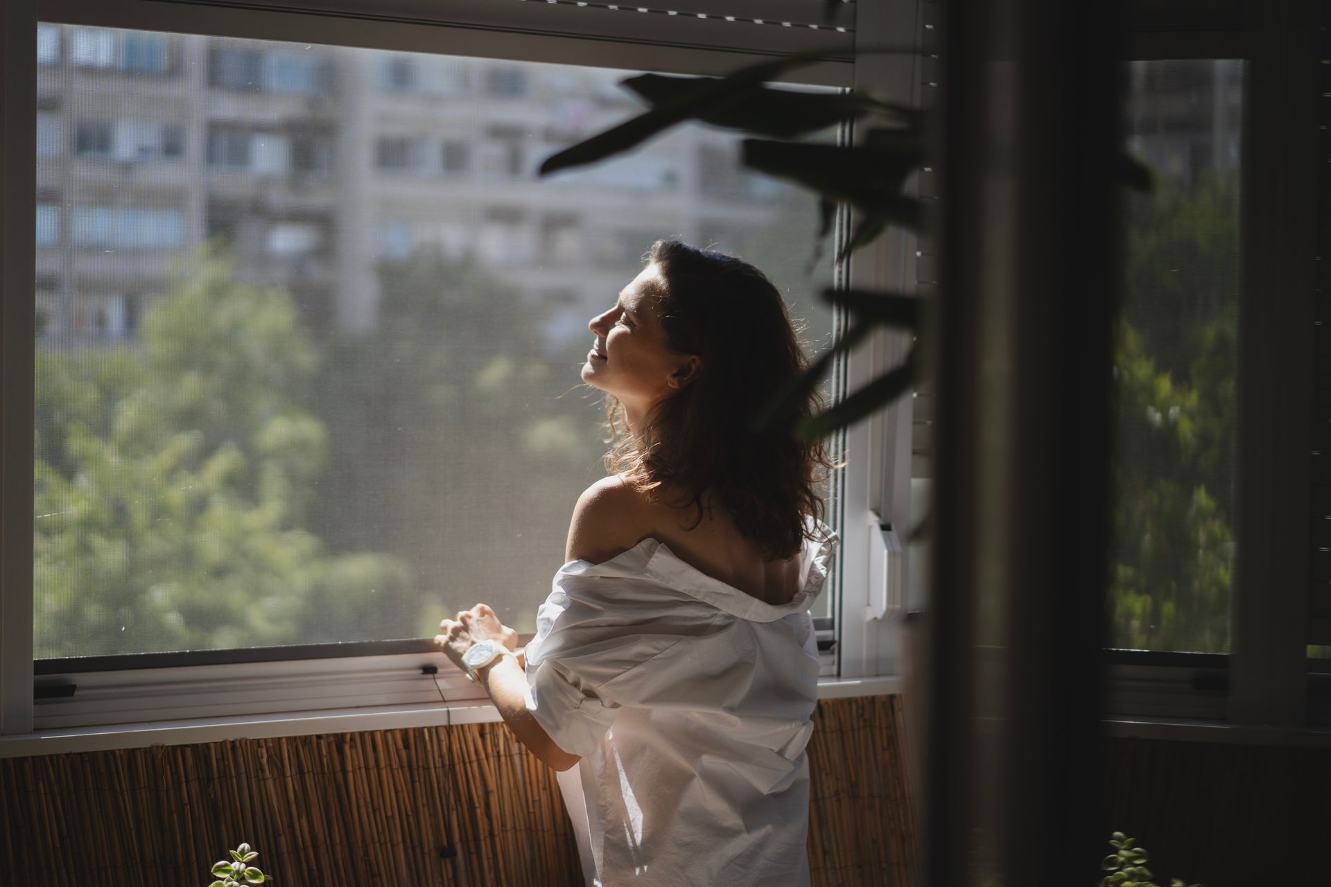 Femme profitant de l'air frais sans problèmes grâce à une moustiquaire.