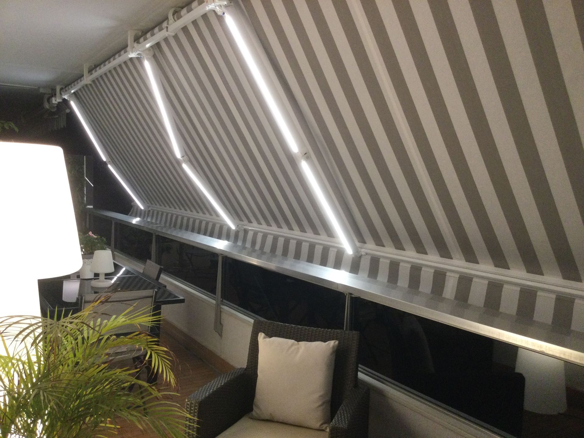 Store à bras éclairé de nuit.