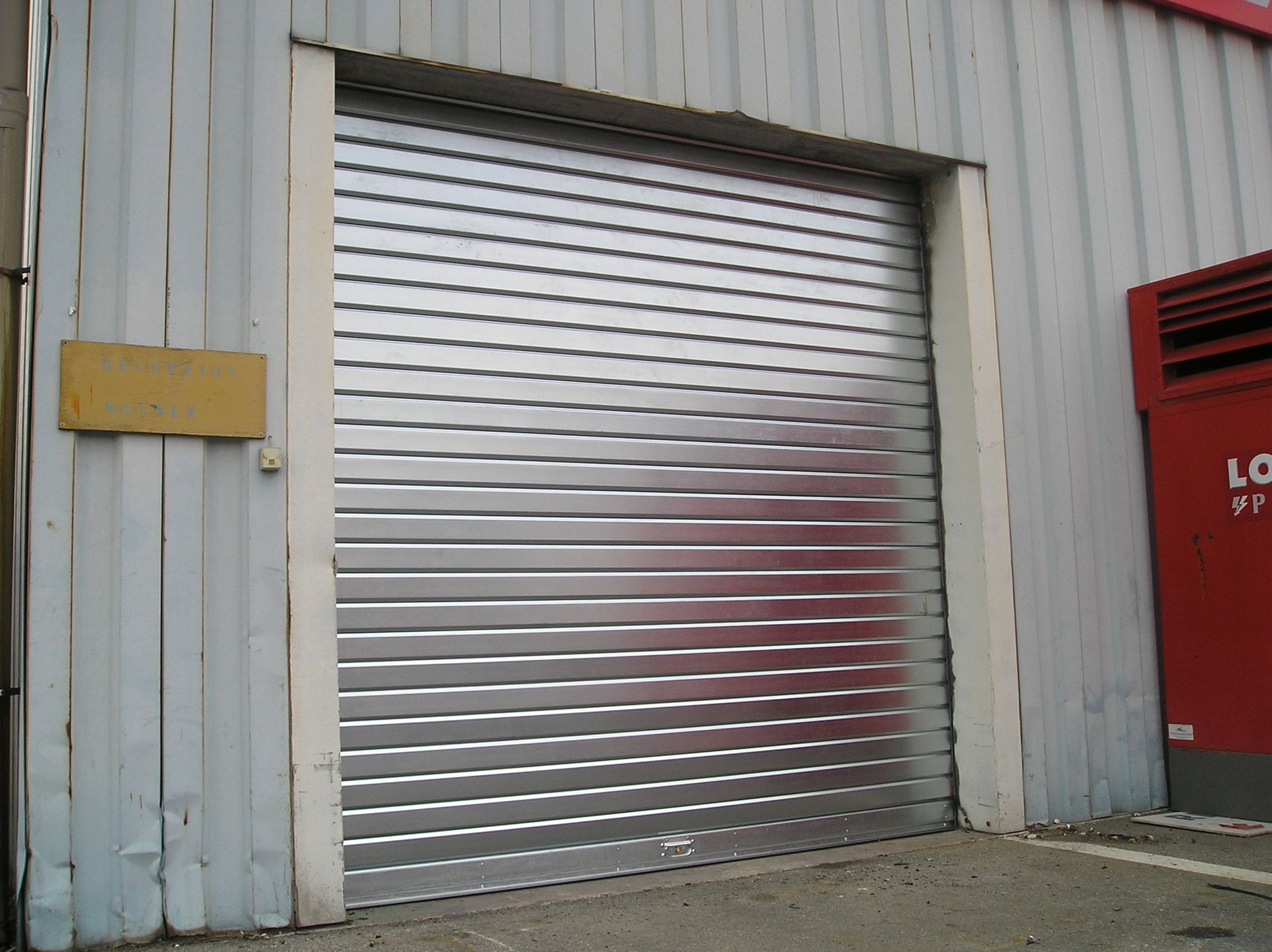 Rideaux métalliques neufs fermés.