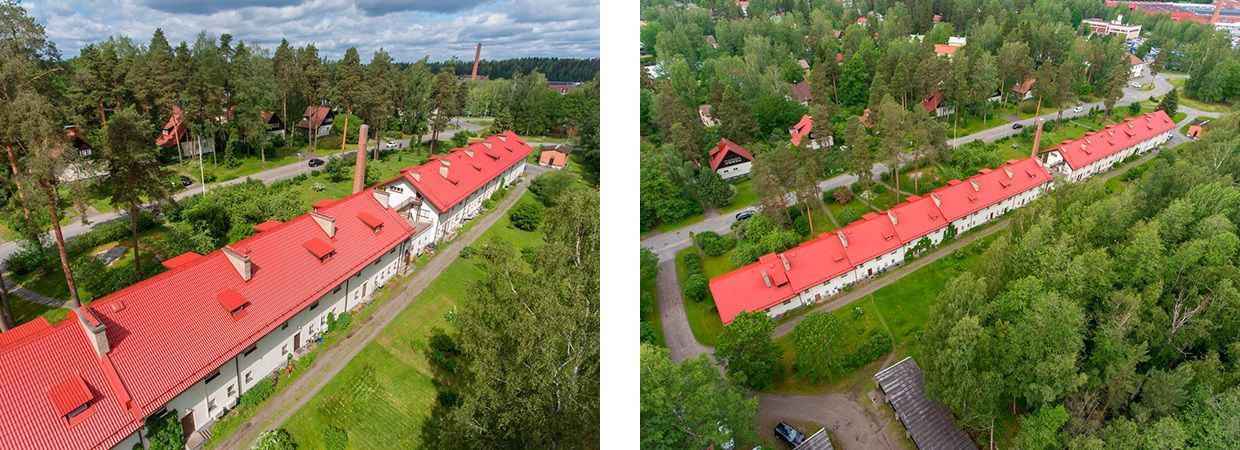 Ilmakuva pitkästä punakattoisesta rakennuksesta rehevien vihreiden puiden ja päällystetyn tien vieressä