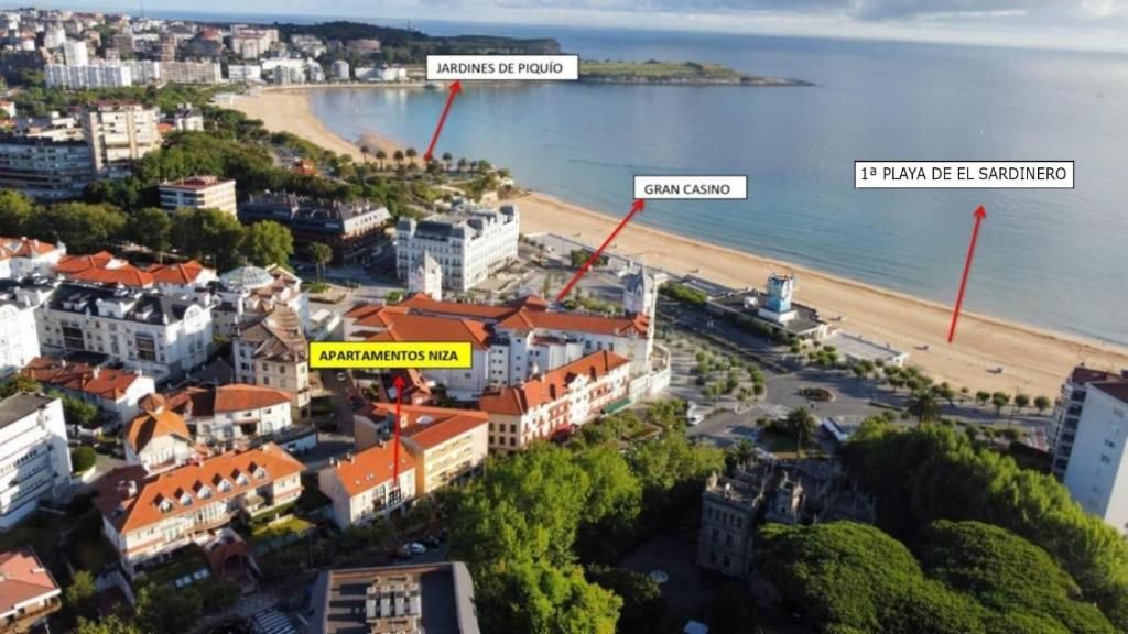 Vista aérea de una ciudad costera con playa, edificios y etiquetas de texto.