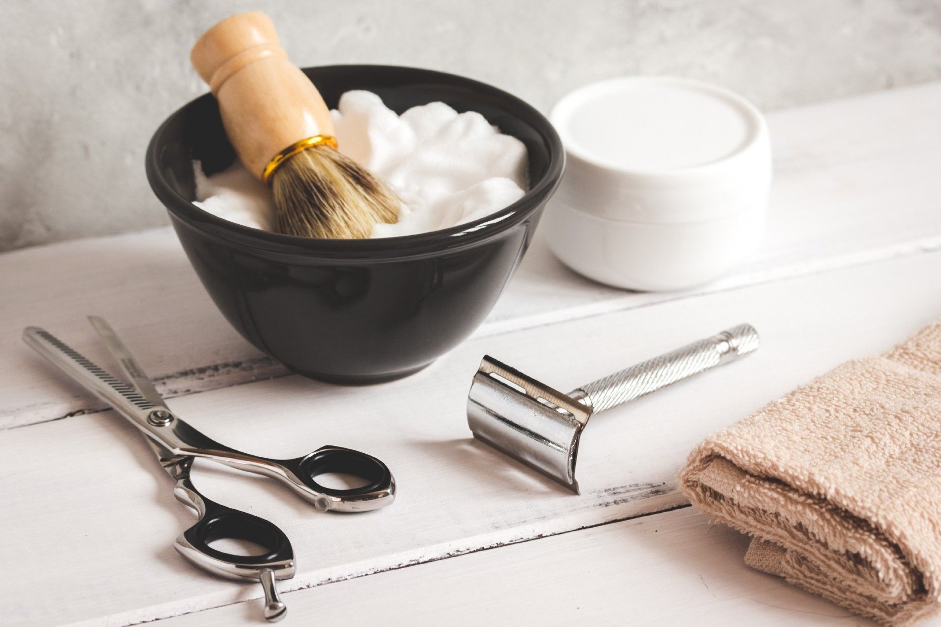Kit de afeitado en madera blanca: bol con brocha, navaja, tijeras, crema y toalla.