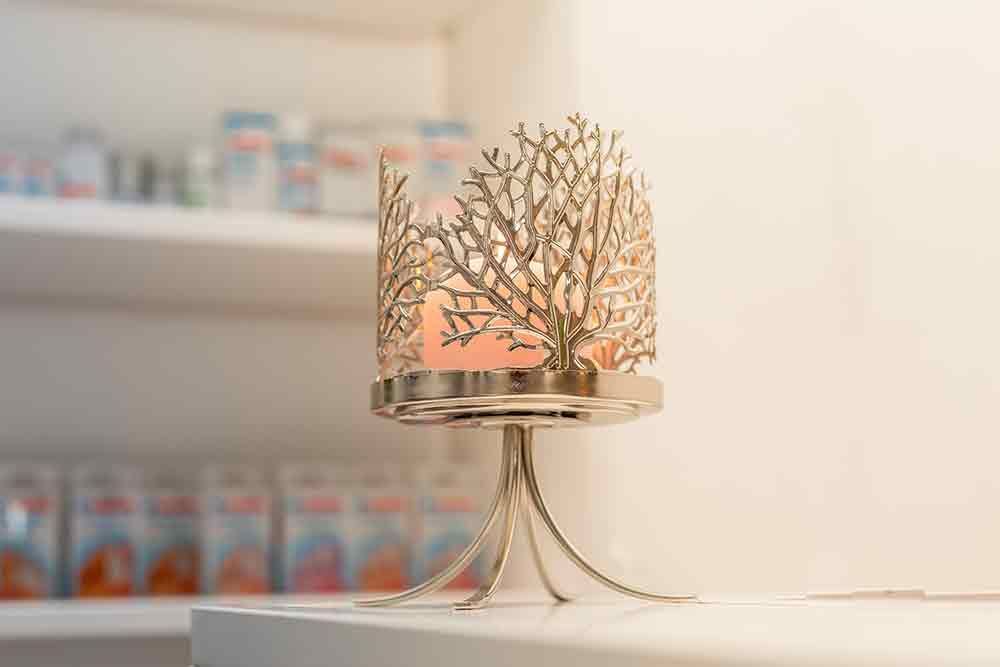 Auf einem Tisch steht ein Kerzenhalter mit einem Baum darauf .