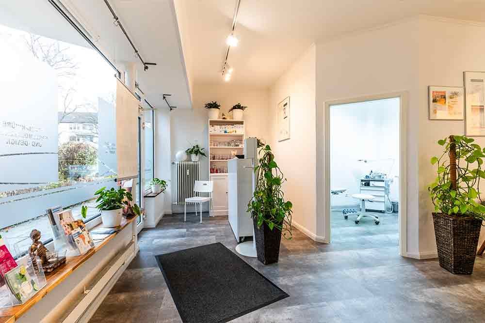 ein Flur in einer Arztpraxis mit einem Teppich und Pflanzen .