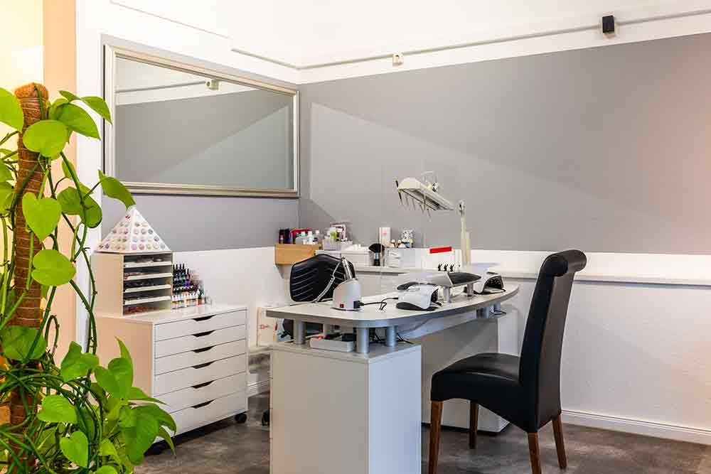 ein Raum mit einem Schreibtisch , einem Stuhl und einer Pflanze .