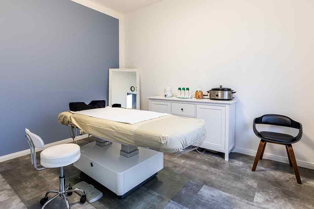 ein Raum mit einem Bett , einem Stuhl und einem Spiegel .