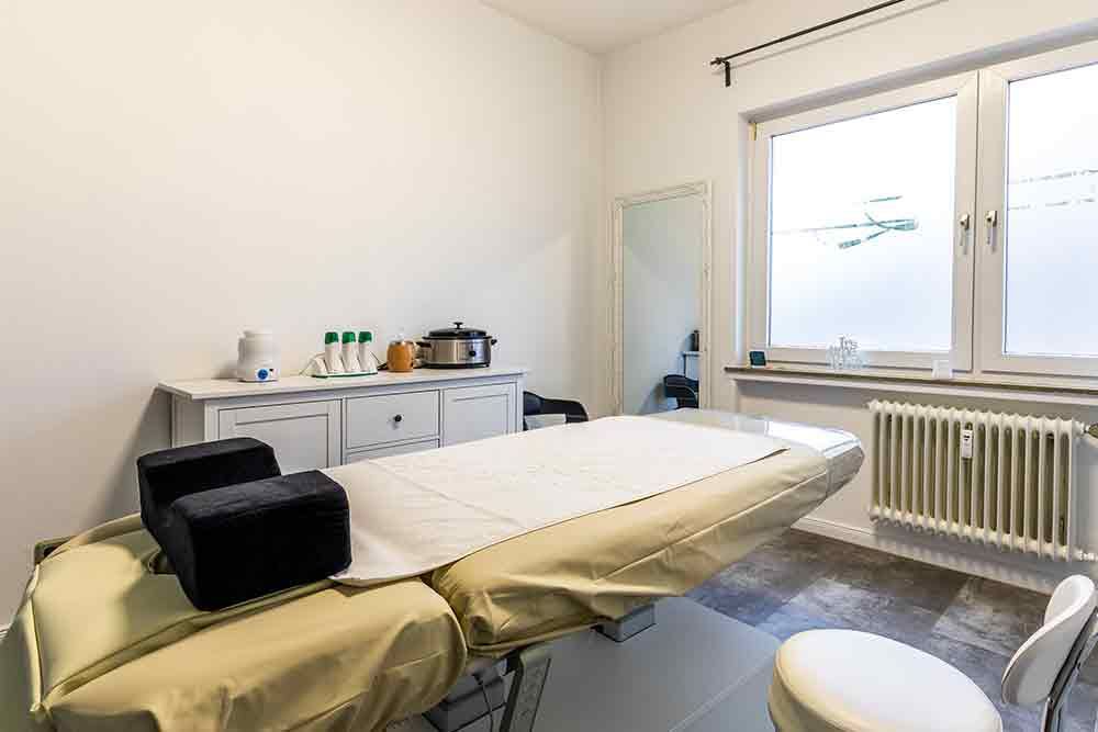 ein Raum mit einem Bett , einem Stuhl und einem Spiegel .