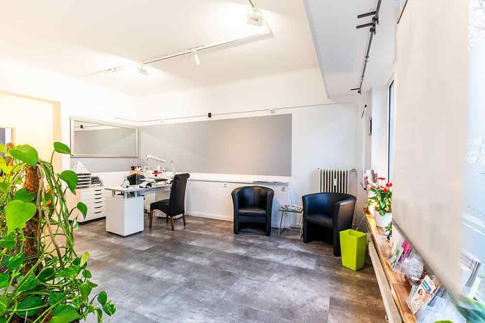 ein Wohnzimmer mit Stühlen , einem Schreibtisch und einer Pflanze .