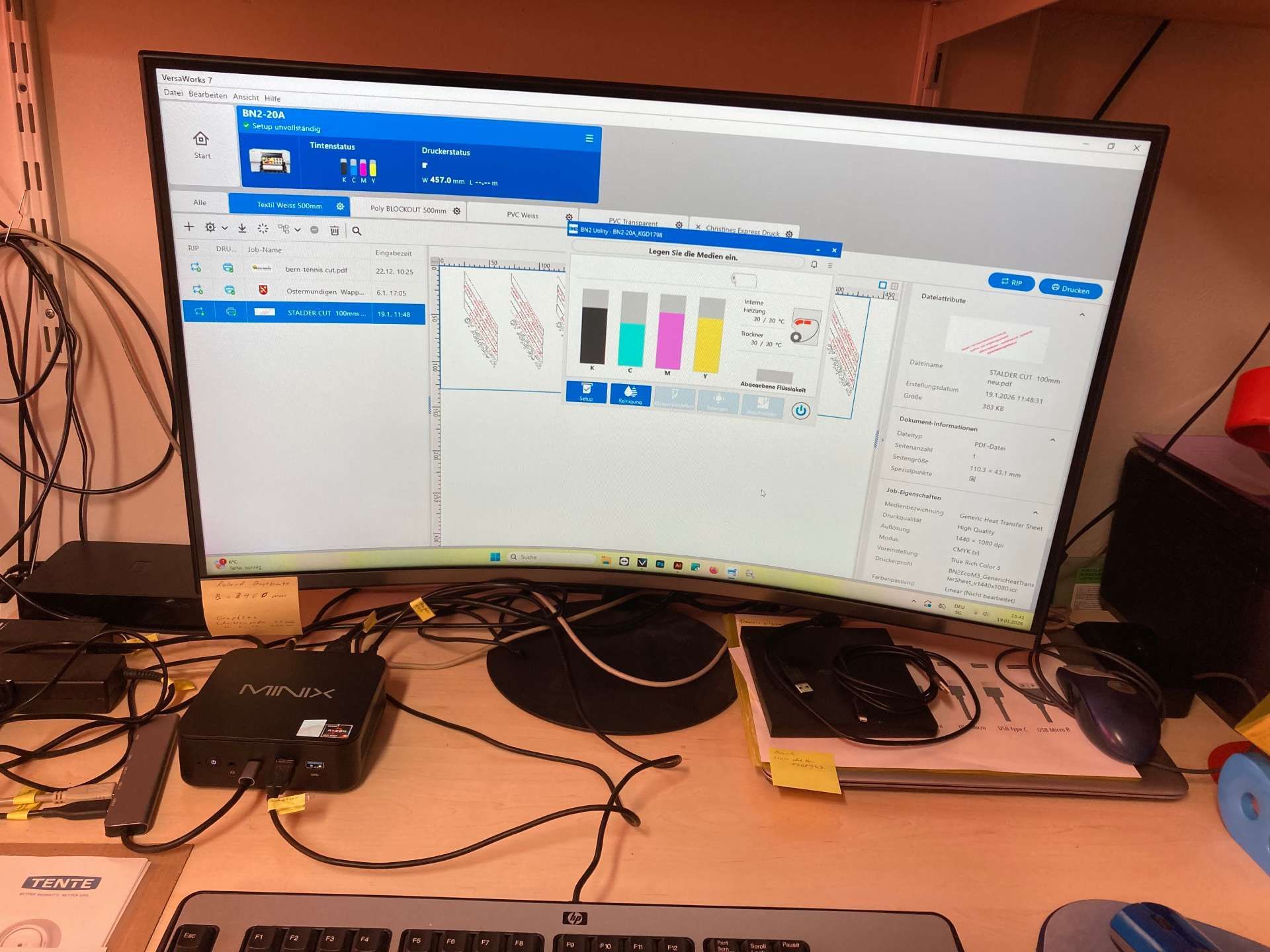 Gebogener Computermonitor mit einer Softwareoberfläche, die Diagramme und Grafiken anzeigt; Kabel und Peripheriegeräte auf dem Schreibtisch.
