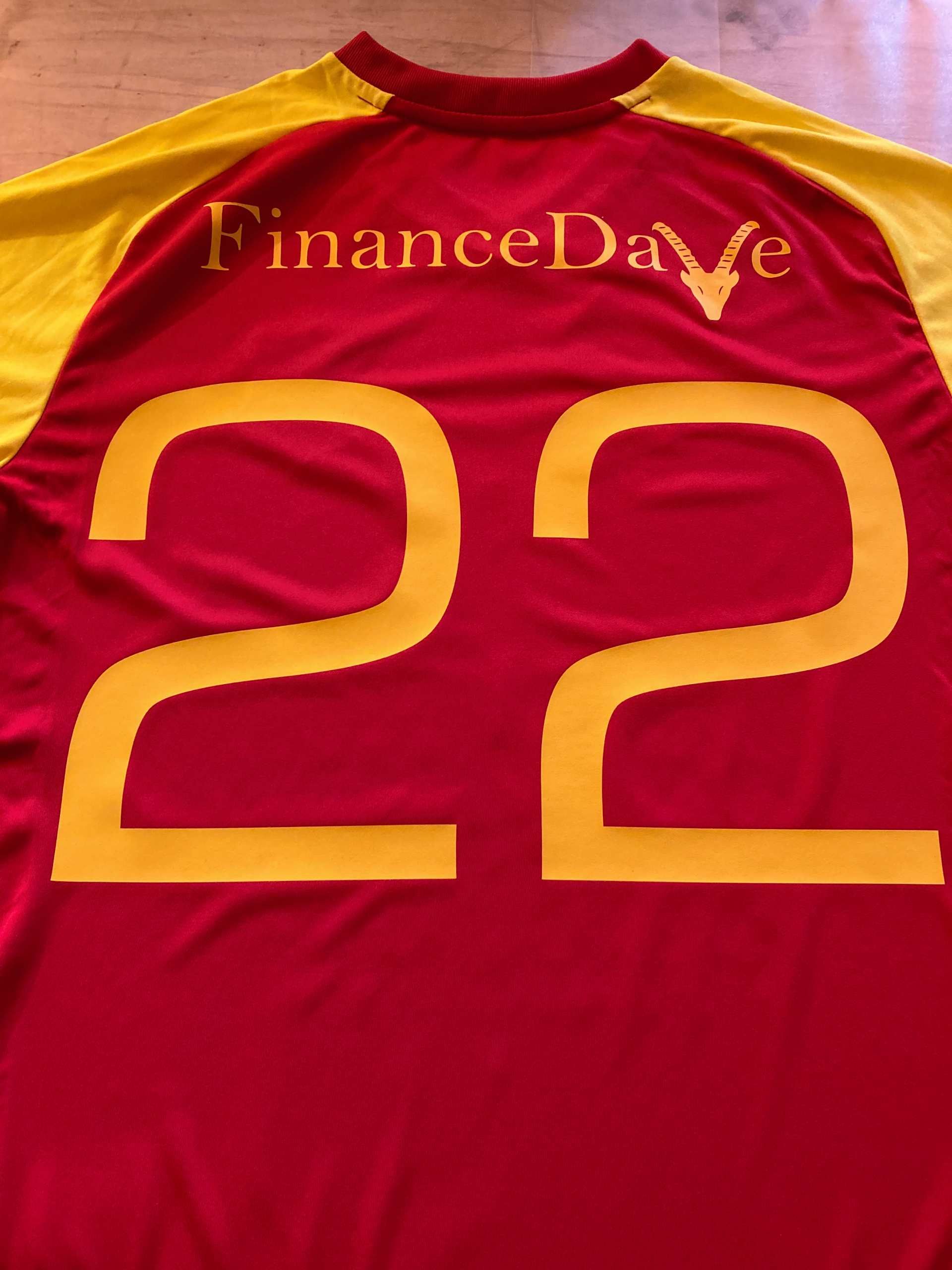 Rot-gelbes Sporttrikot mit der Aufschrift „FinanceDave“ und der Nummer 22.