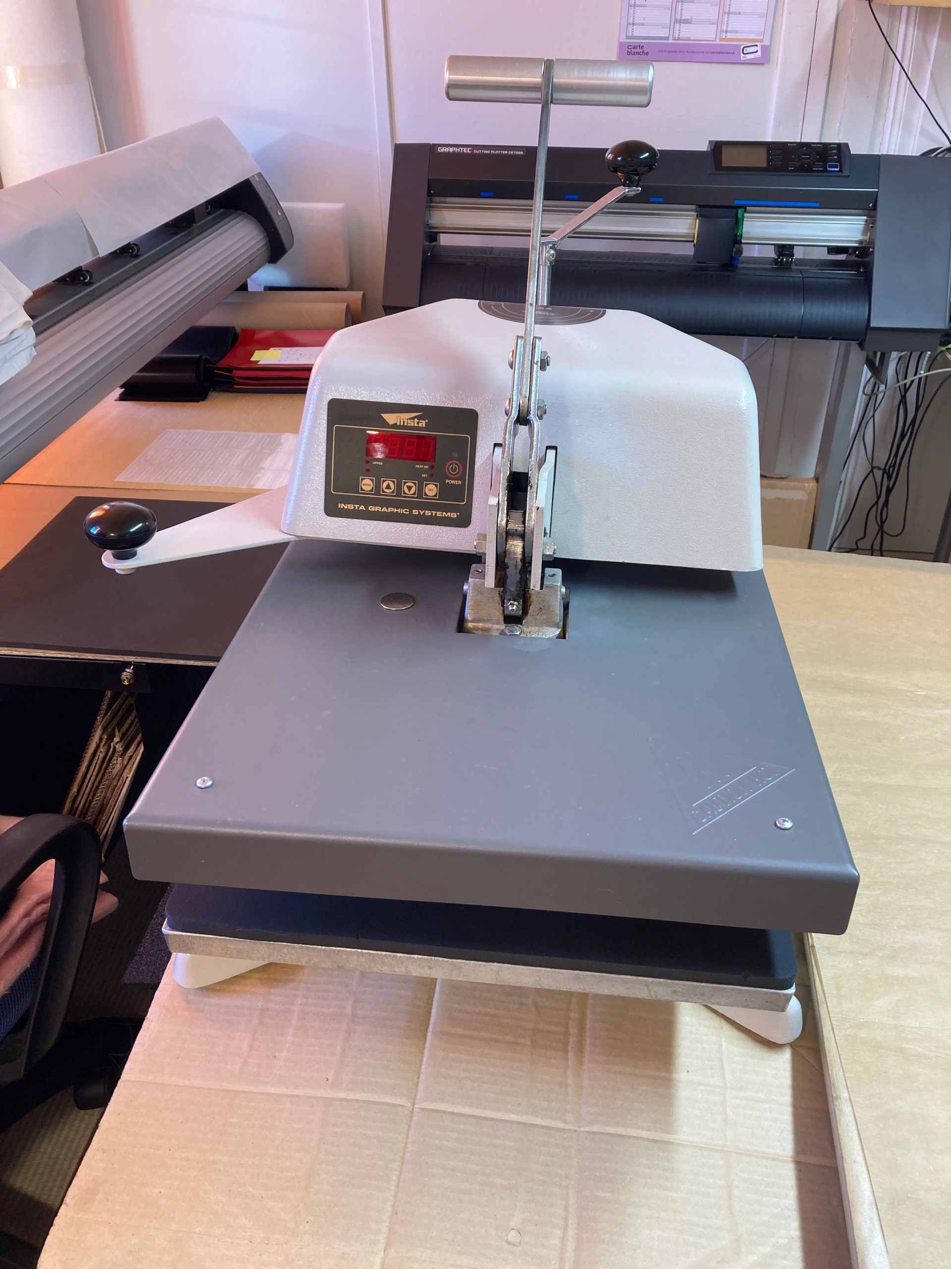 Transferpresse auf einem Tisch; grau-weisses Farbschema, Digitalanzeige.