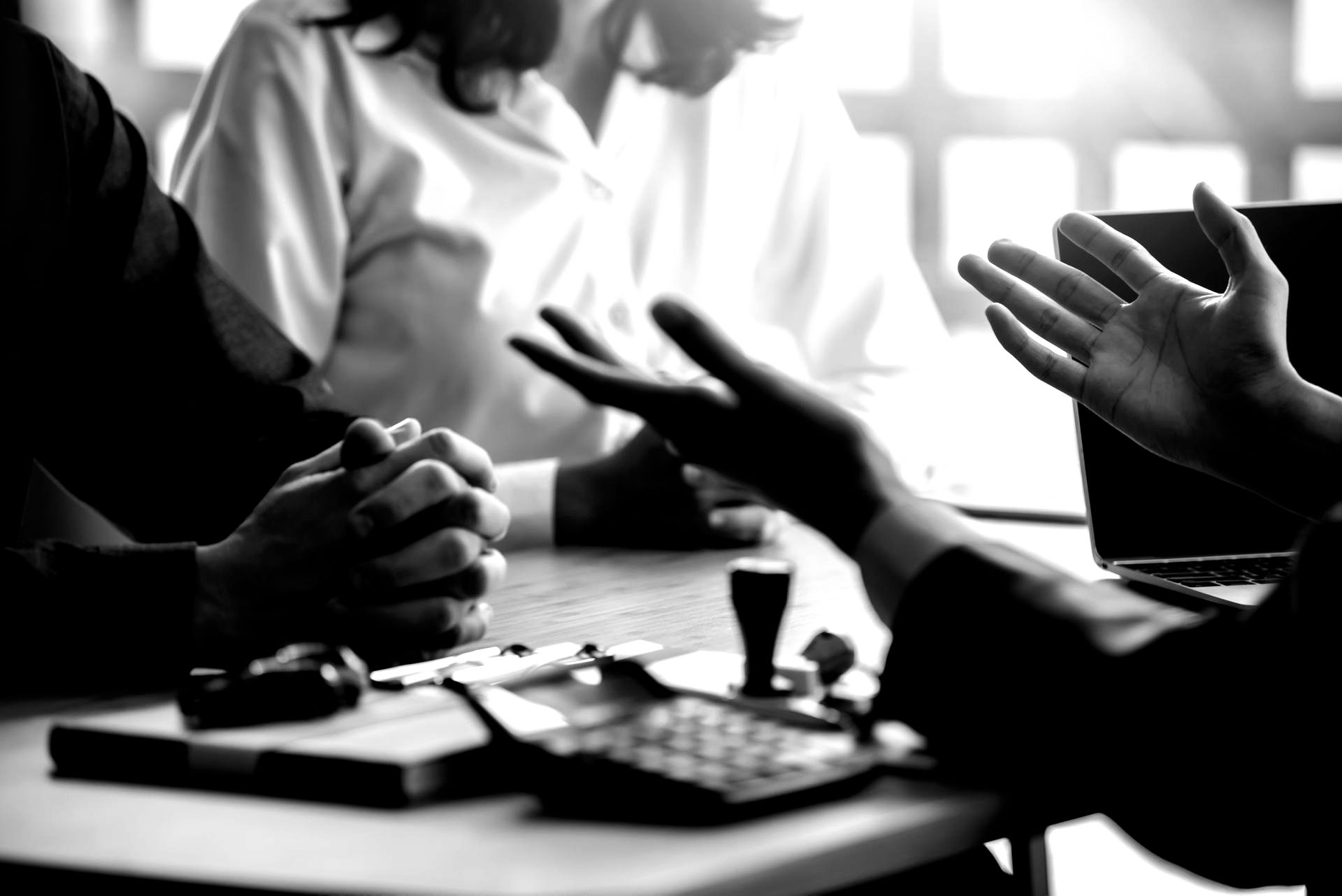 Homme avec les mains écartées expliquant des choses à un couple en face de lui