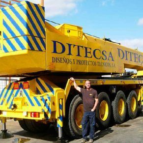 Un hombre se encuentra frente a un gran camión amarillo que dice ditecsa