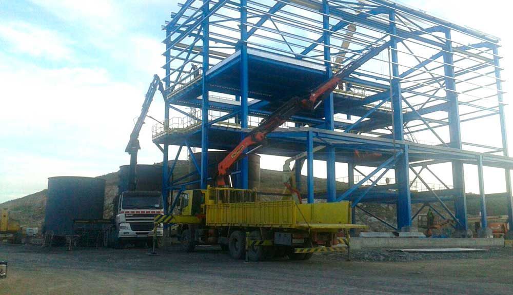 Un camión amarillo está estacionado frente a un edificio en construcción.
