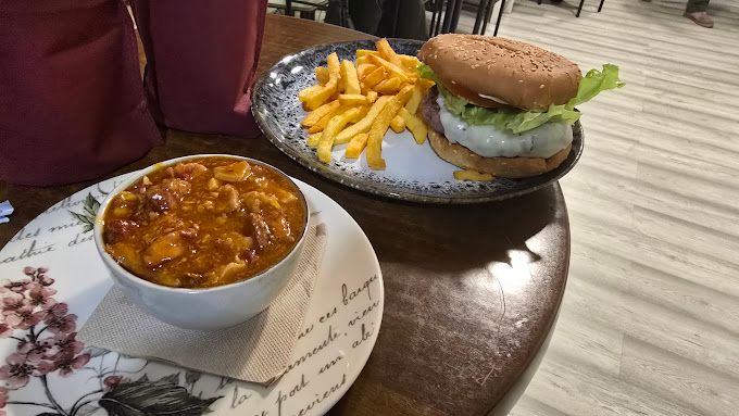 Un tazón de chile y un plato de papas fritas están sobre una mesa.