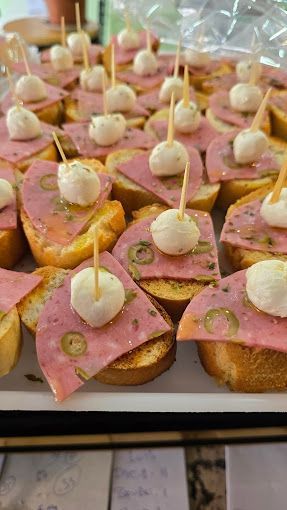Un montón de sándwiches con carne y queso en palillos sobre una mesa.