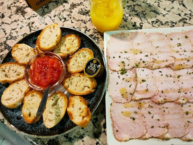 Un plato de pan al lado de un plato de carne en una mesa.