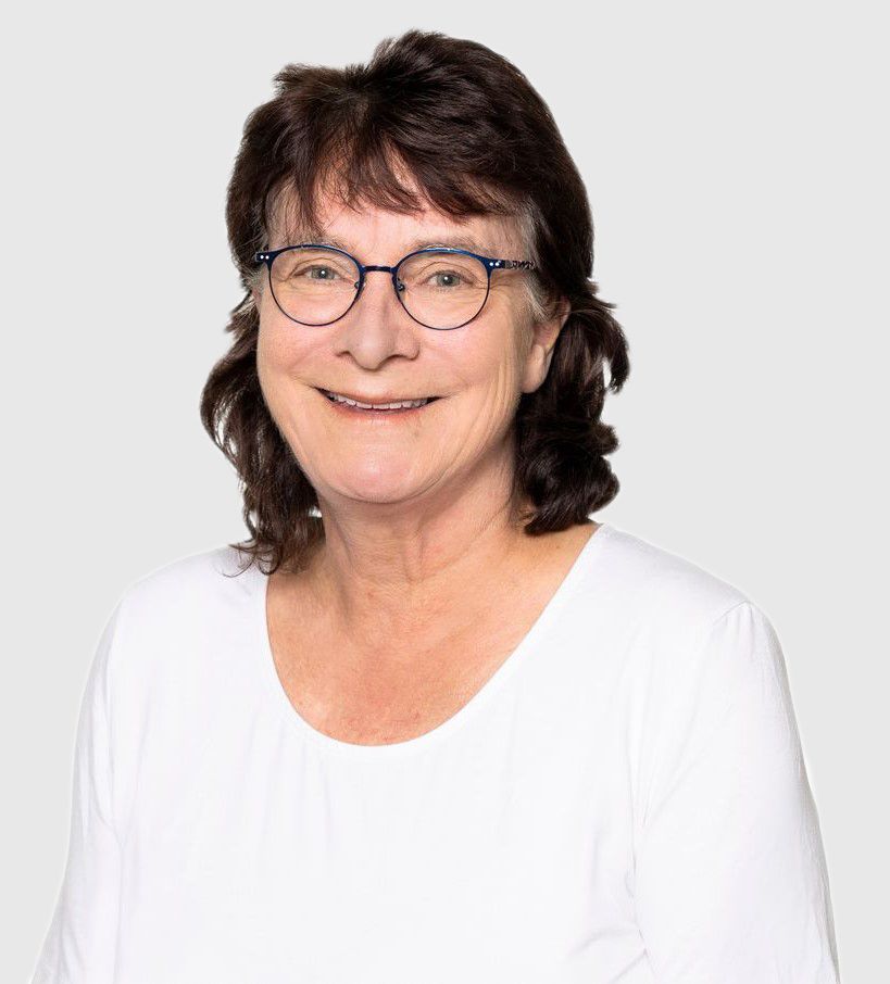 Eine Gruppe von Menschen sitzt in einem Klassenzimmer und sieht einem Mann zu, der einen Vortrag hält.