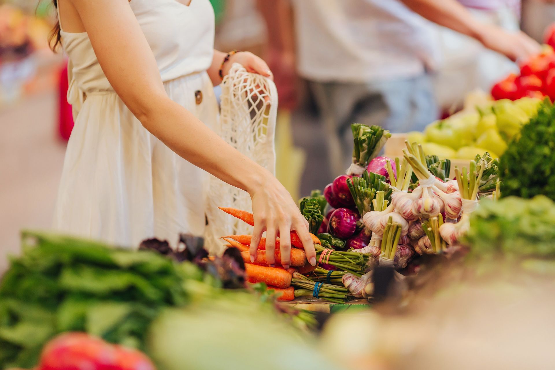 Femme au marché choisissant des légumes
