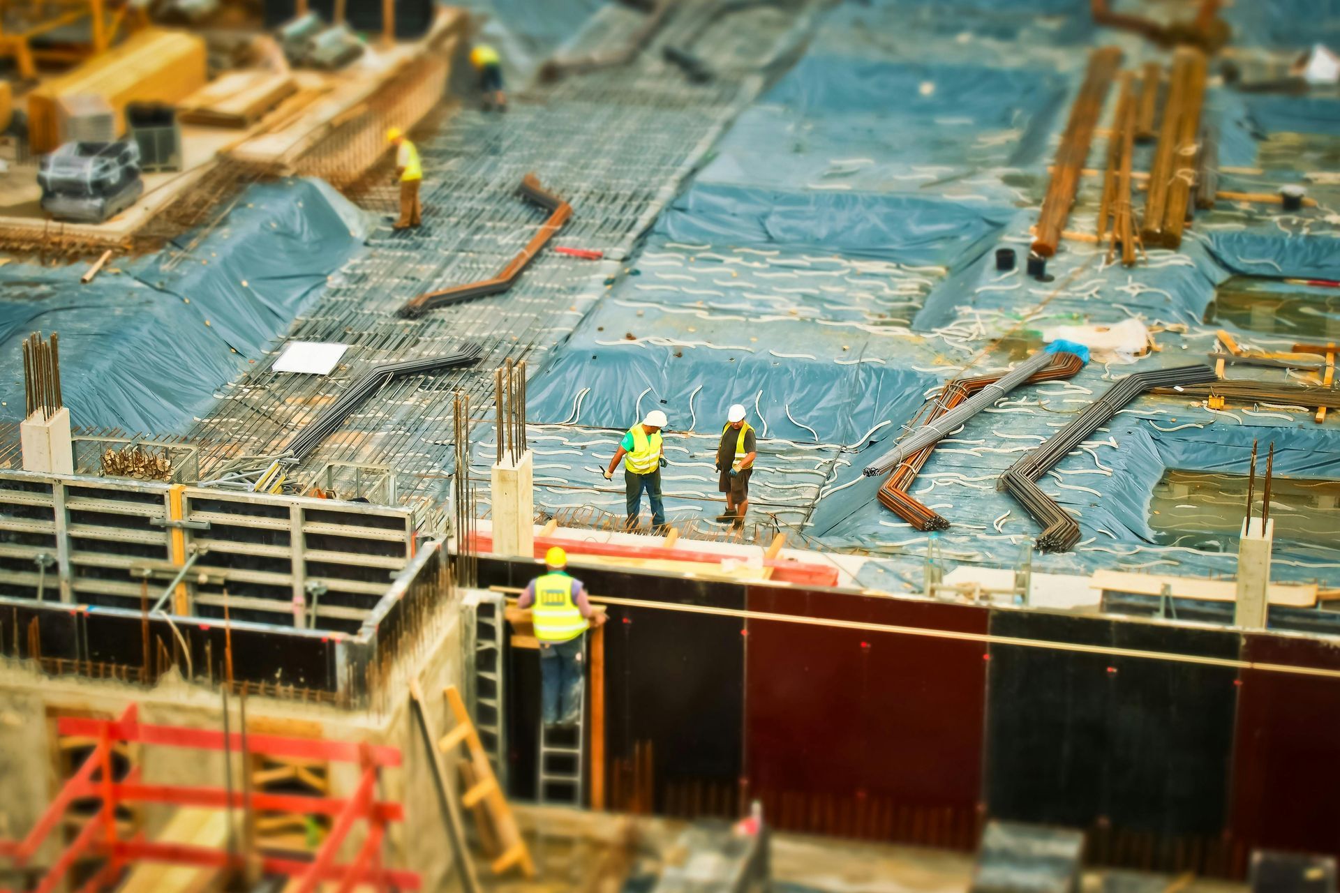 Un grupo de trabajadores de la construcción se encuentra en la parte superior de un sitio de construcción.