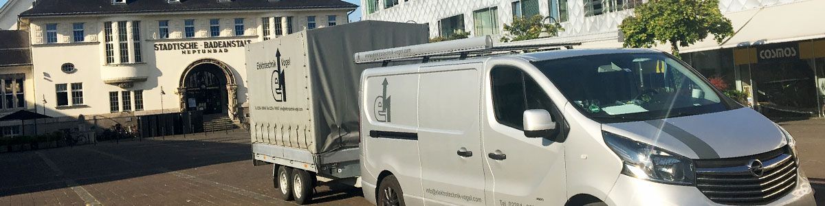 Ein weißer Lieferwagen steht vor einem Gebäude.