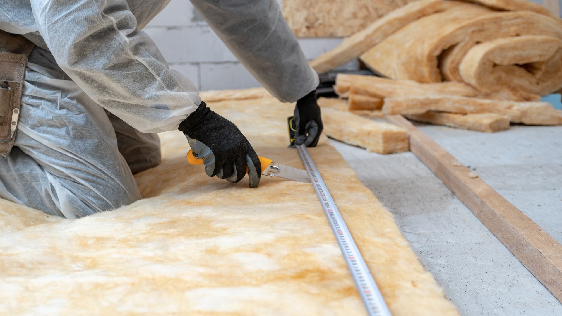 Un artisan qui découpe un isolant