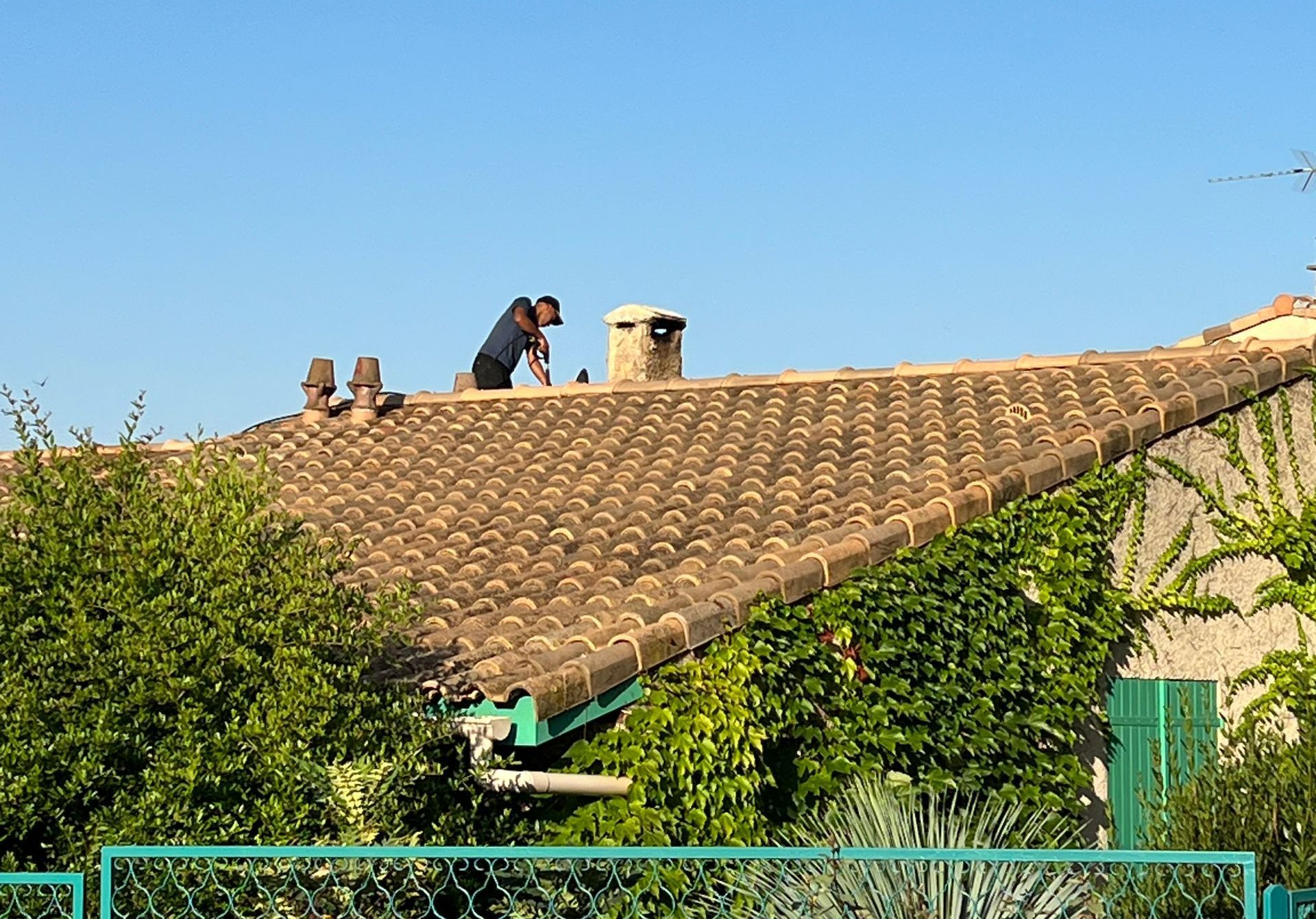 Un artisan qui travaille sur une toiture avec des outils adaptés.