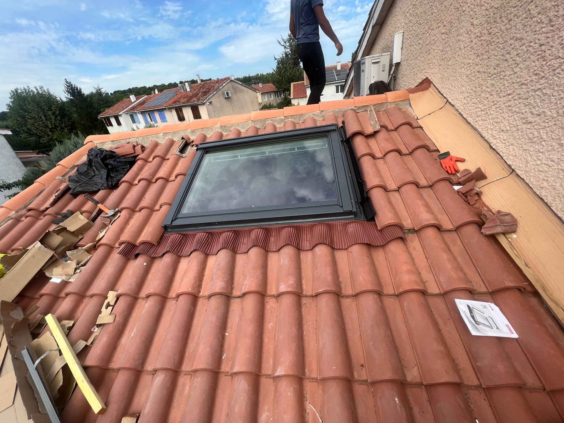 Des artisans qui posent une fenêtre de toit