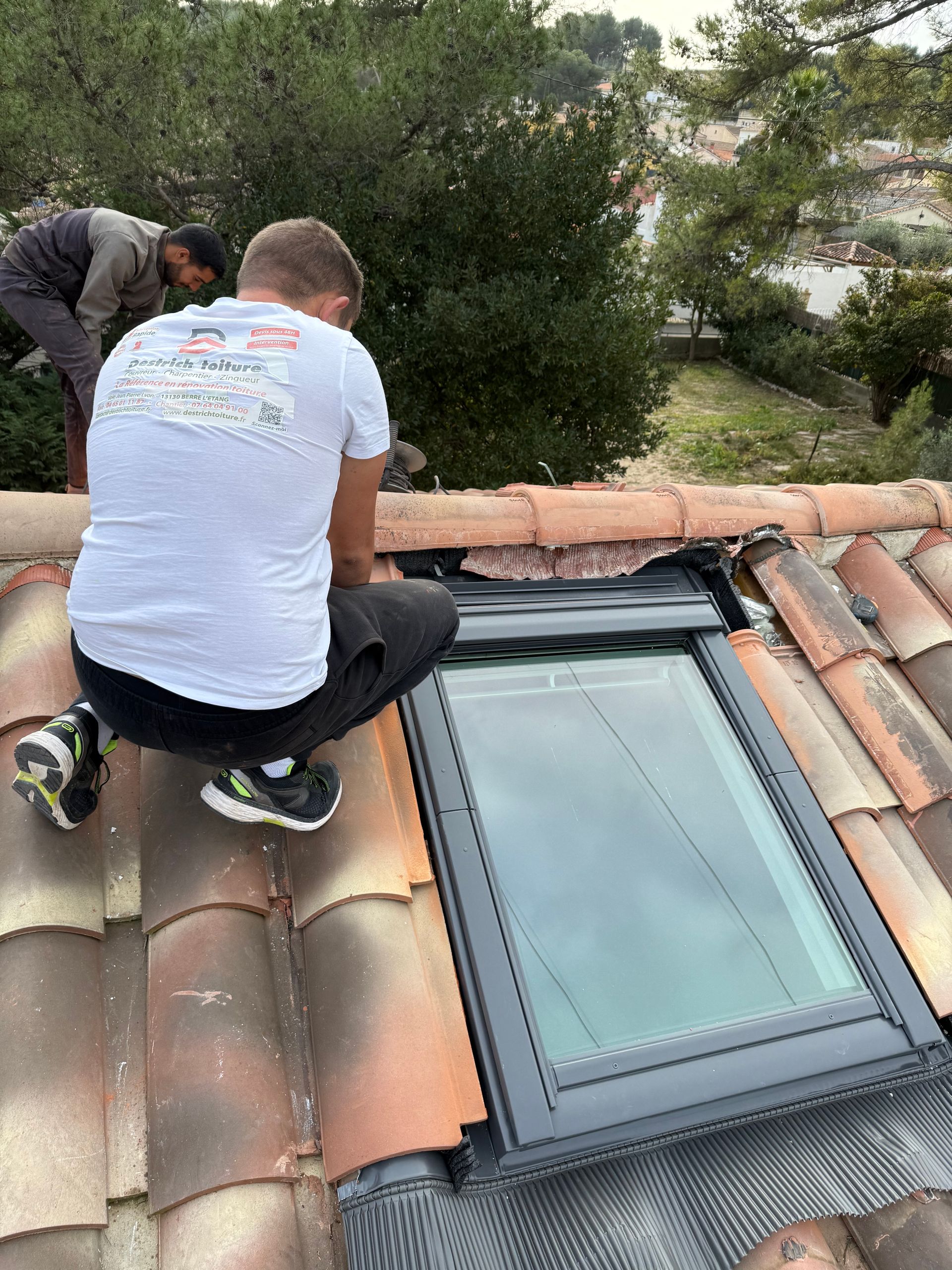 Un artisan qui pose une fenêtre de toit