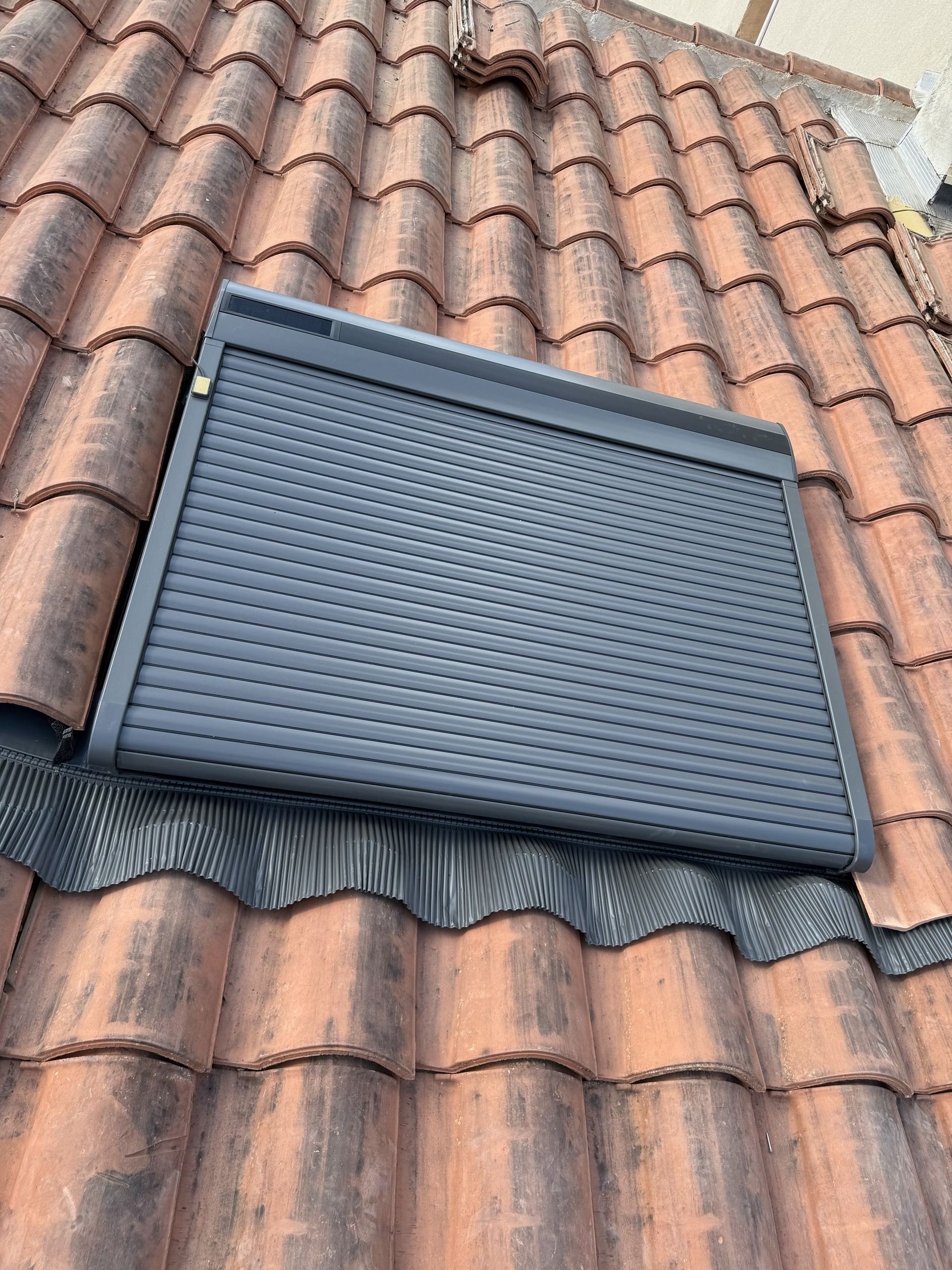 Un volet roulant sur une fenêtre de toit