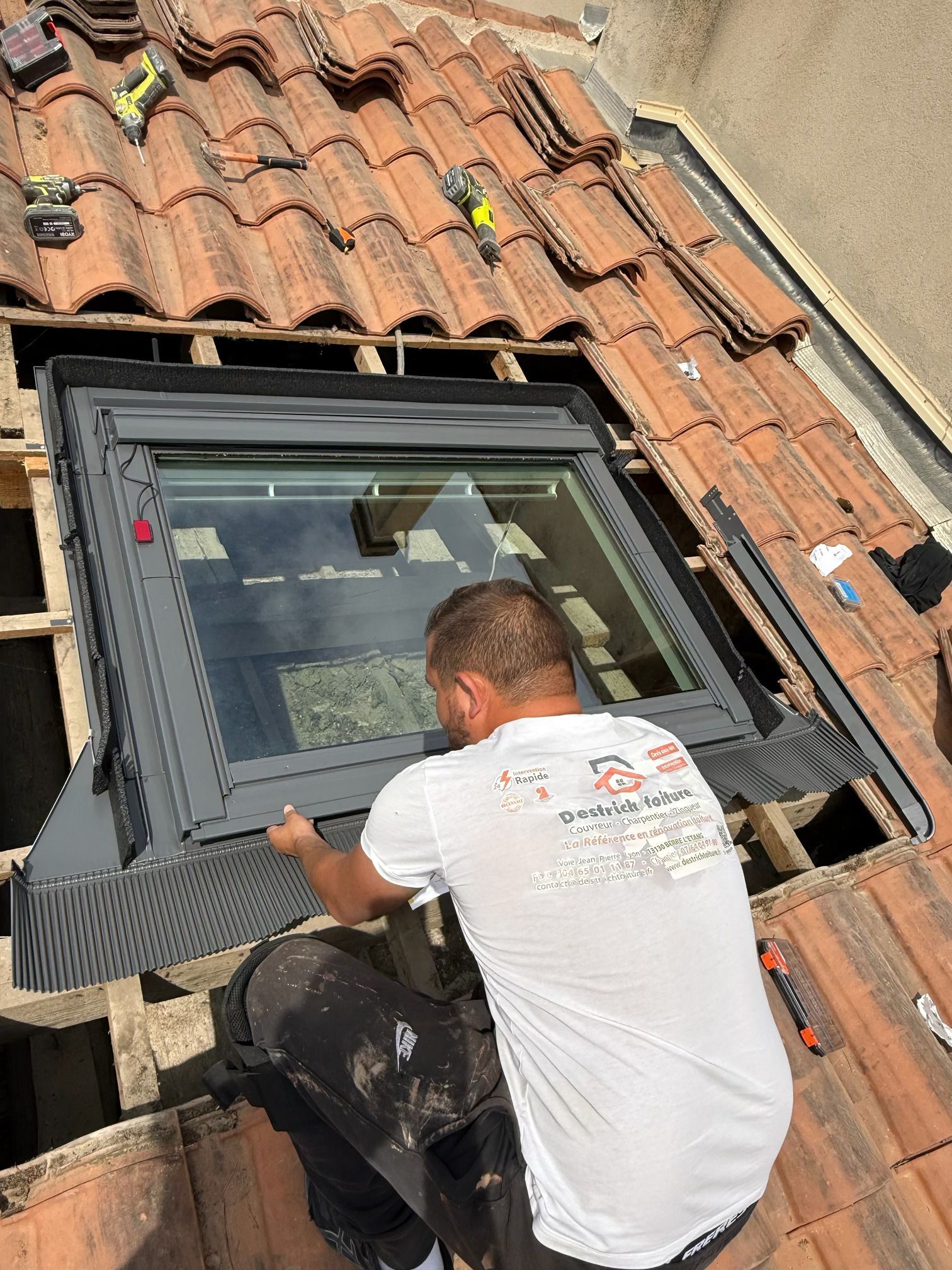 Un homme installant une fenêtre de toit