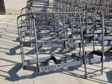Reihen grauer Metall-Einkaufswagen stapeln sich auf einem Parkplatz unter hellem Sonnenlicht.