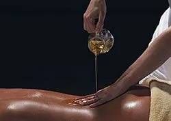 Un amas de pierres, des bougies, un diffuseur et des fleurs sur une table, créant une ambiance digne d'un spa.