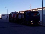 Un camión está estacionado al costado de la carretera frente a un edificio.