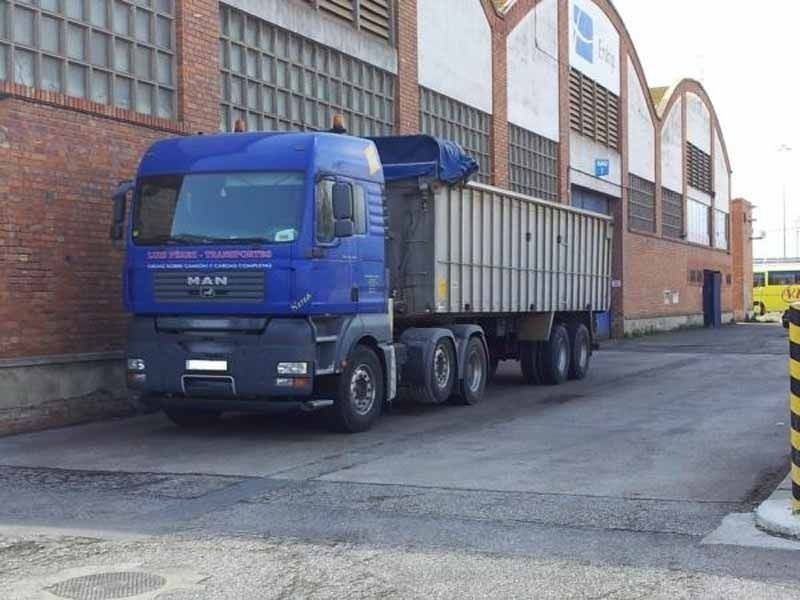 Un camión de Blue Man está estacionado frente a un edificio de ladrillos.
