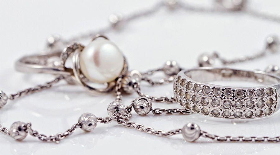 Anillos de diamantes y oro expuestos sobre una superficie oscura, con varios de ellos borrosos al fondo.