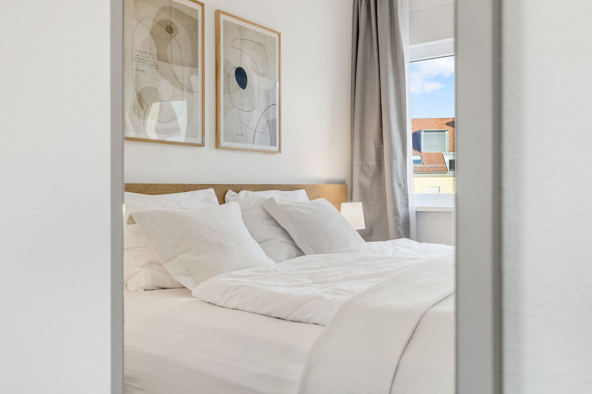 Ein Schlafzimmer mit einem großen Bett und zwei Gemälden an der Wand.