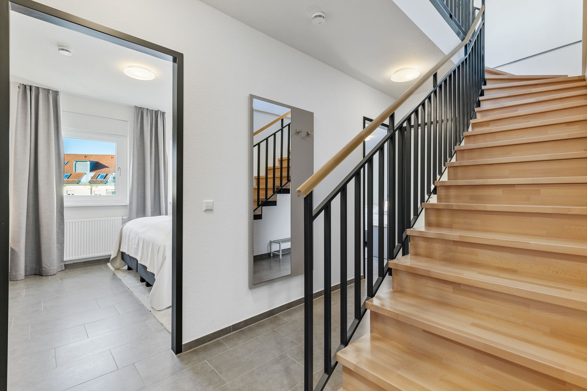 Eine Holztreppe, die in den zweiten Stock einer Ferienwohnung nahe Freiburg führt führt.