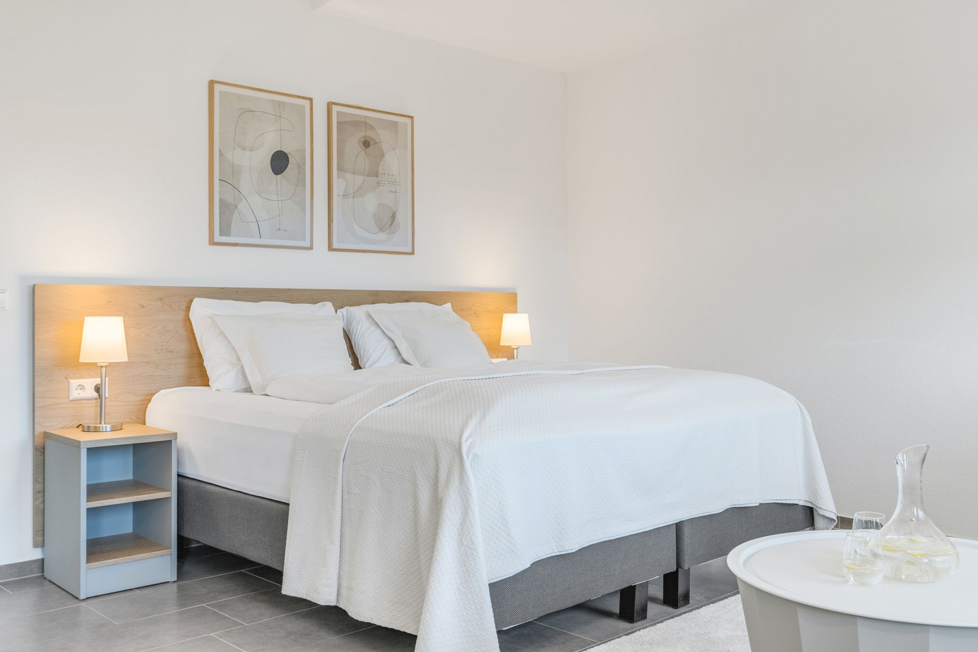 In der Mitte des Zimmers steht ein großes Boxspringbett.