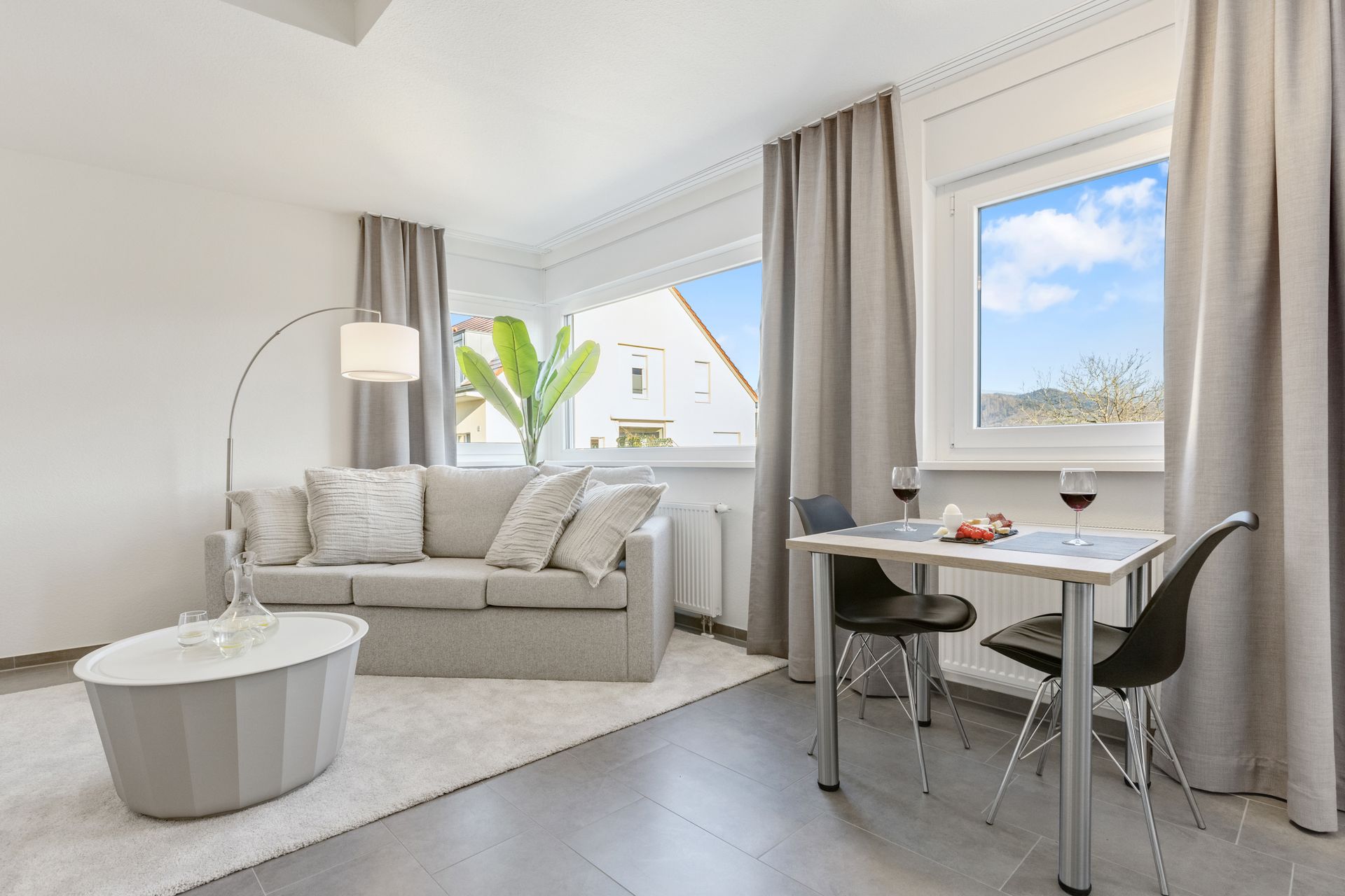 Ein Studio Apartment als Ferienwohnung mit Sofa, Tisch und Stühlen.