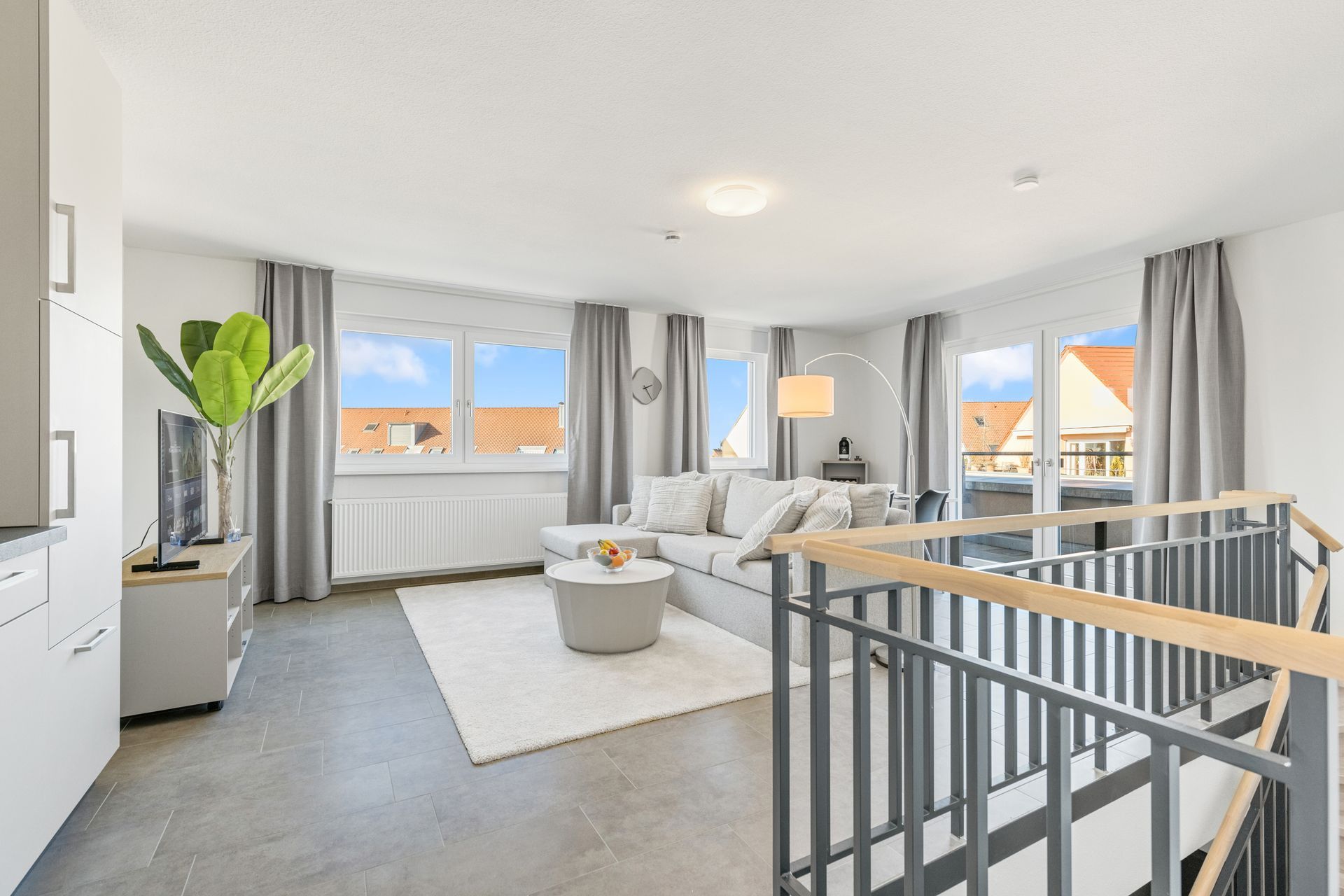 Ein Airbnb Apartment mit Sofa, Tisch und Treppe, die in den zweiten Stock führt.