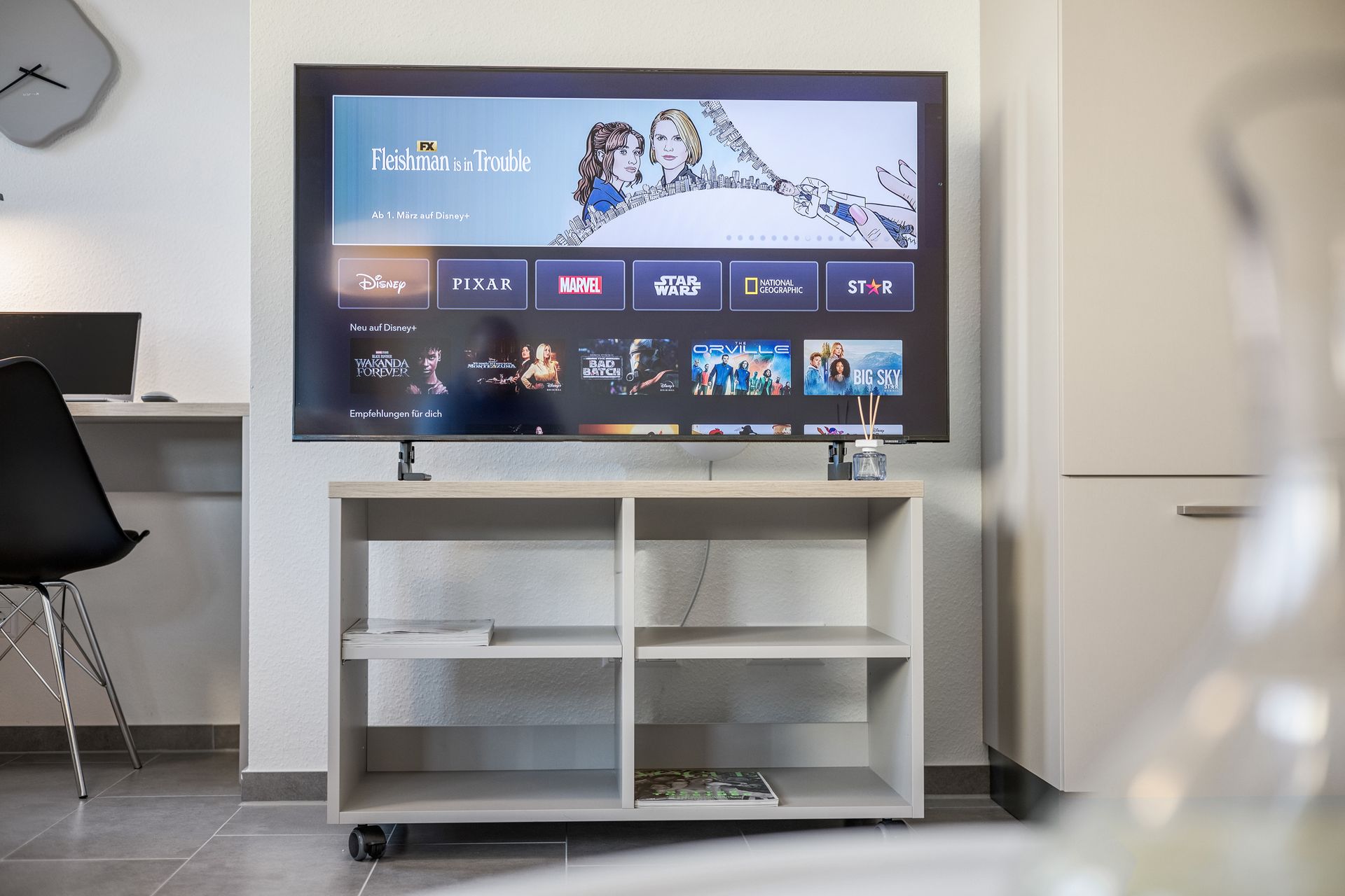 Ein Smart TV mit Netlfix und Disney+ steht auf einem Regal in einem Studio Apartment nahe Waldkirch.